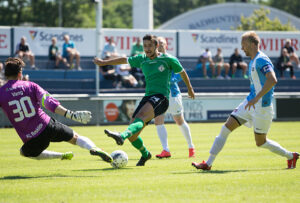 FODBOLD: Aleksandar Lazarevic (FC Helsingør) afslutter imellem målmand Frederik Vang og anfører Ander Møller Christensen (FC Roskilde) under træningskampen mellem  FC Helsingør og FC Roskilde den 11. juli 2015 på Helsingør Stadion. Foto: Claus Birch Foto: Claus Birch